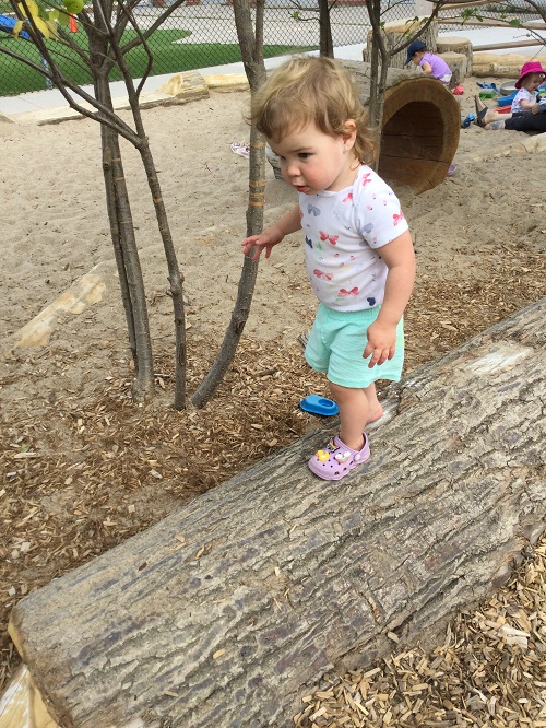 a child walking across a log using their balancing skills