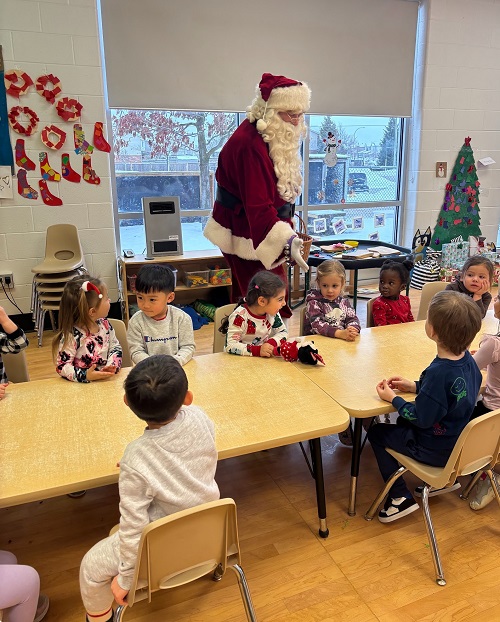 santa visiting a group of children sitting around a table
