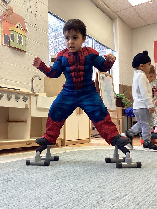 child standing and balancing on pushup bar handles