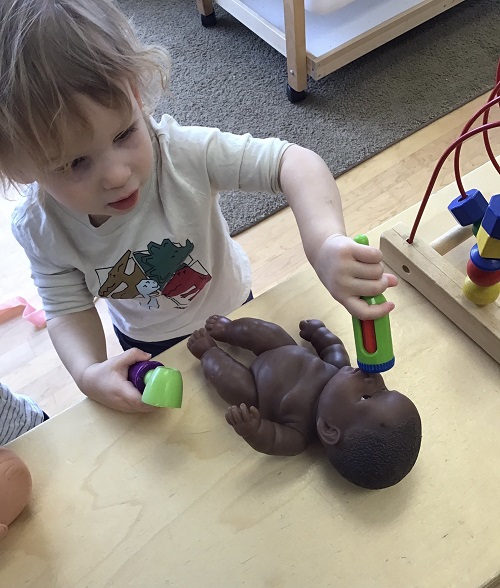 Child checking temperature on a doll