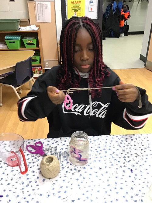 child at a table making a crystalized salt creation