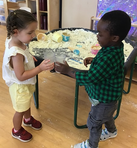 two children doing "cheers" with pretend lemonade