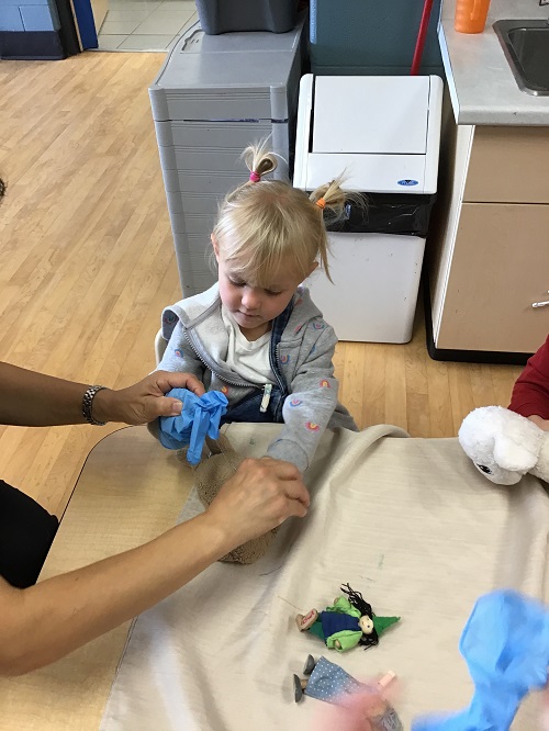 child with educator and gloves 