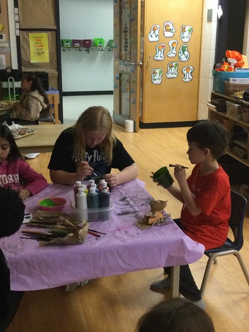 2 kids painting pots