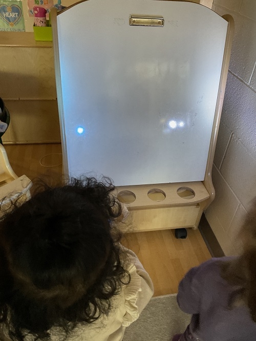 The toddlers in Toddler 1 at RisingOaks Early Learning | St. Patrick, have been exploring light and reflection through hands-on experiences with flashlights, mirrors, translucent blocks, and coloured lenses.