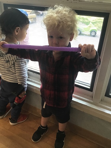 Child playing with purple tube