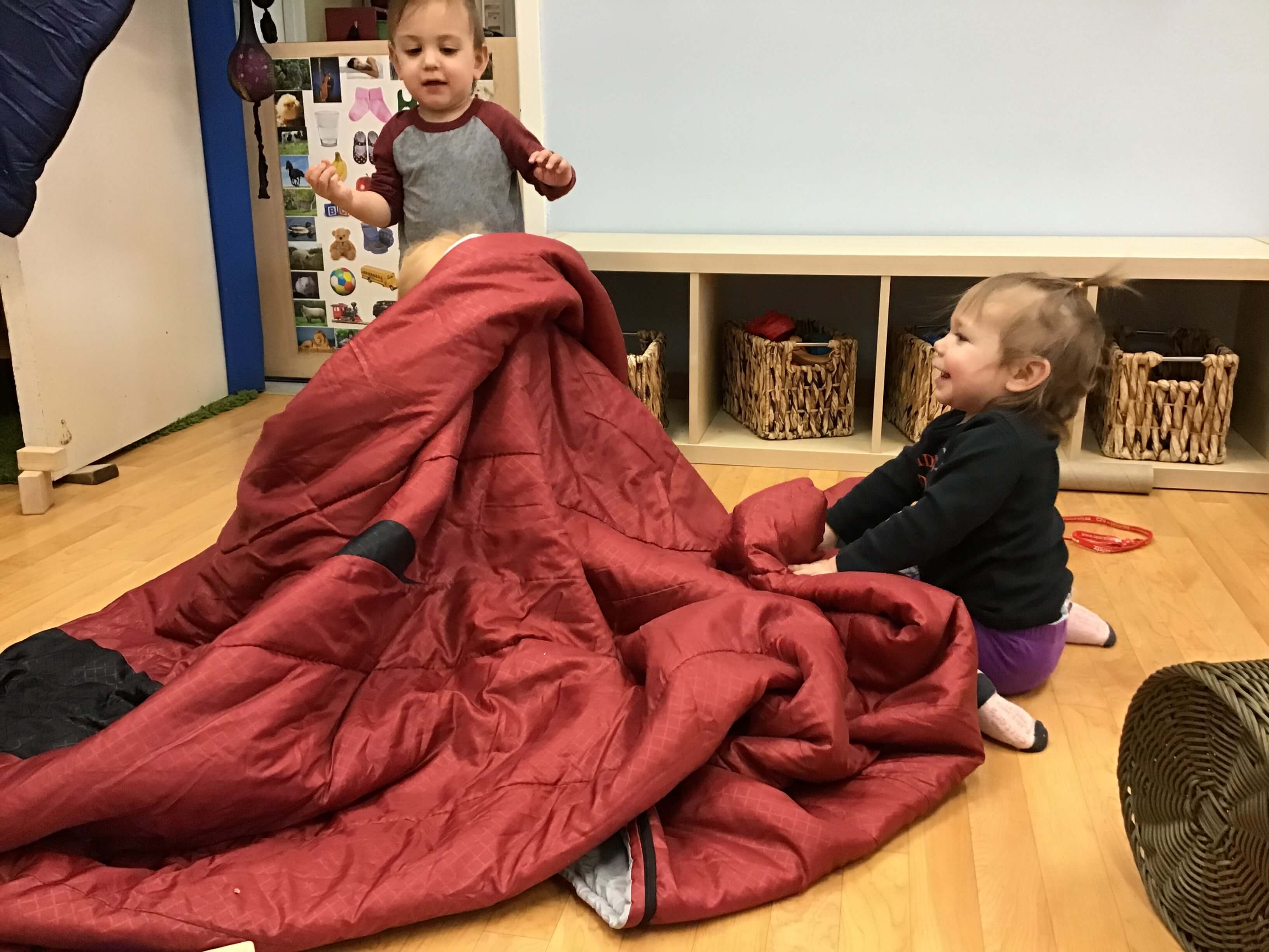 children hiding under a blanket