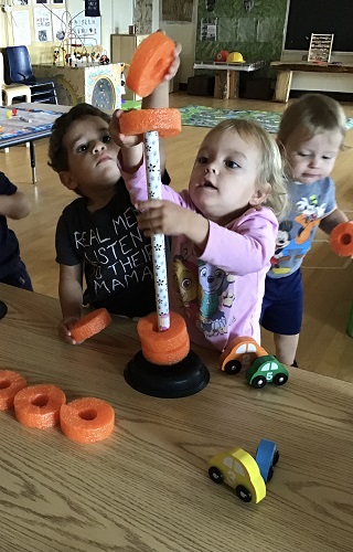 Toddlers put pool noodles onto a plunger