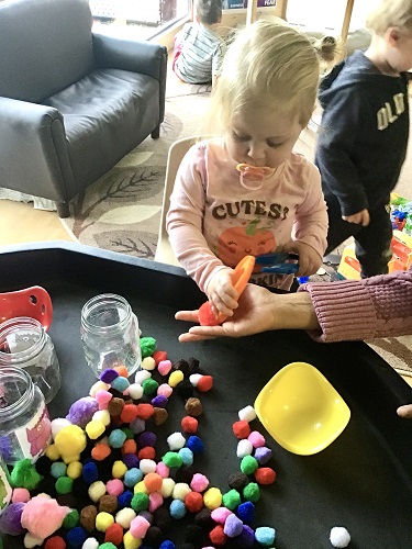 preschool girl sorting pom poms