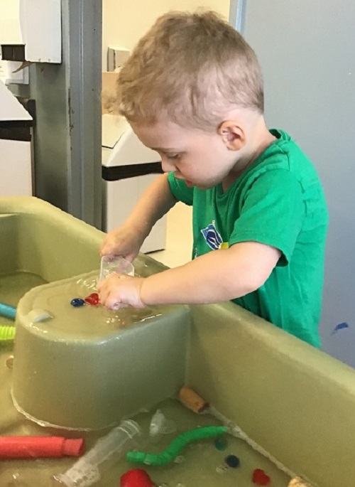 Preschool boy using small loose parts