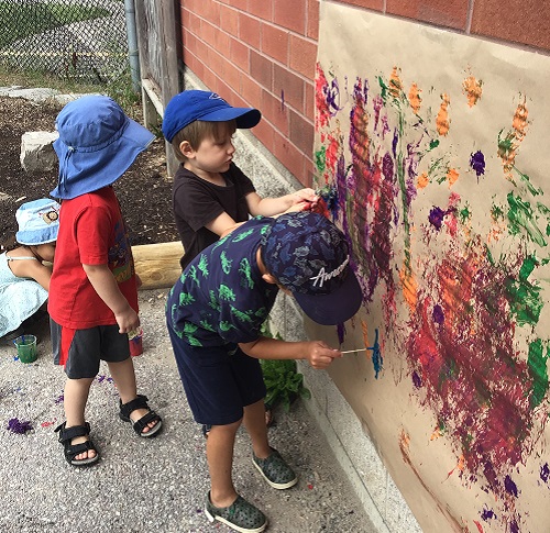 preschool children painting outside