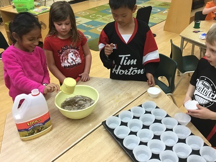 Group of children pouring oil into batter 