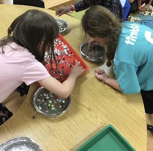 children sorting through beads