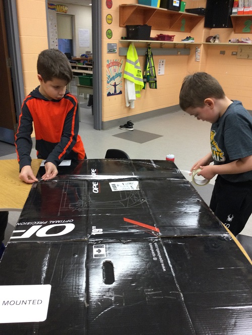children taping a box together