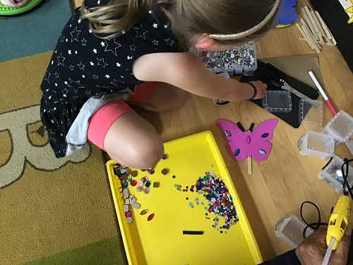 child putting gems onto their butterfly