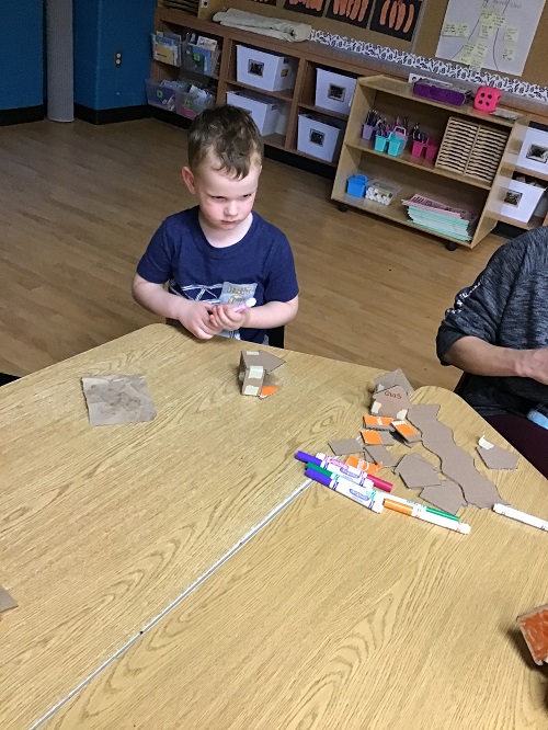 child placing a house together