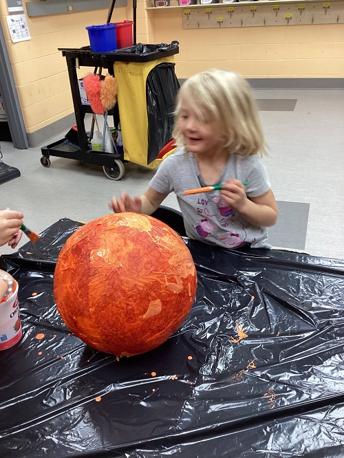 child painting their structure