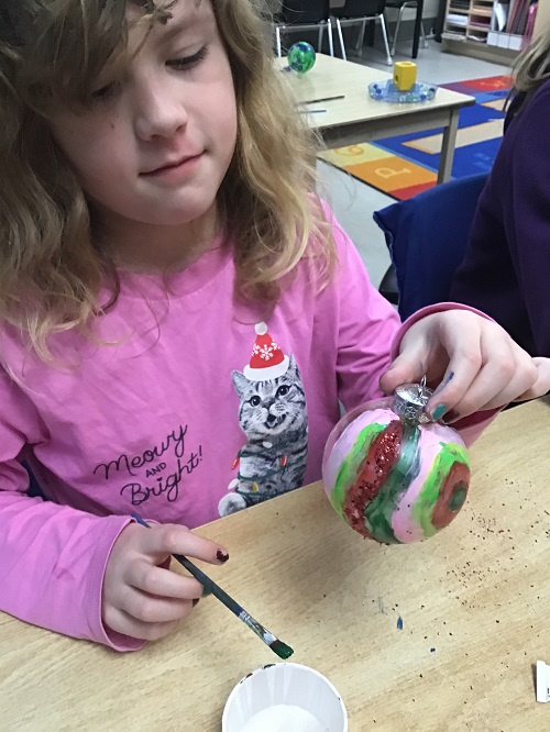 Child holding up painted ornament