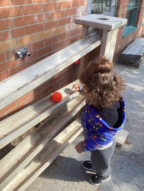 child exploring the ball run outside