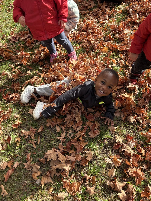 Child jumping in the leaves