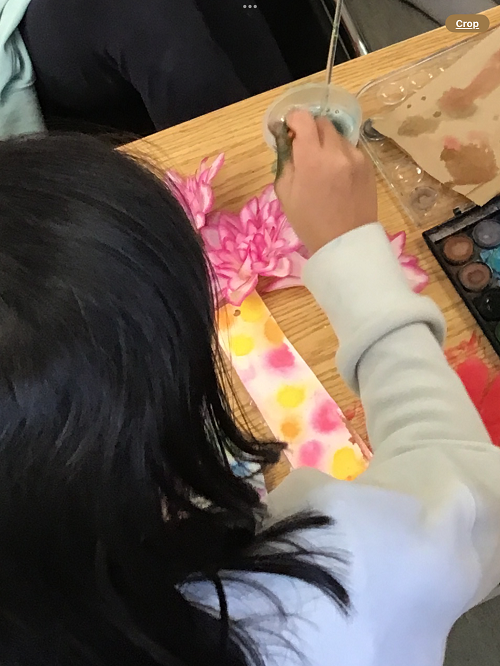 child working on painting their bookmark