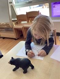 girl drawing a bear figure