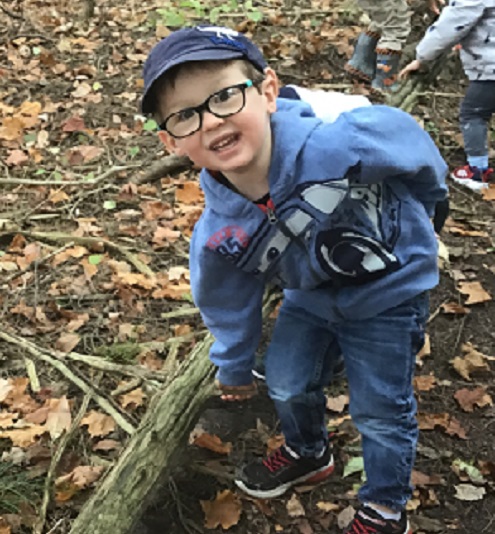 Preschool child pointing to a log