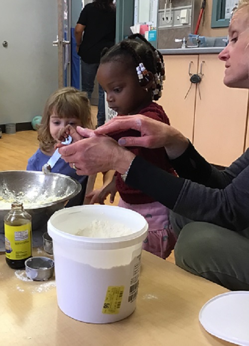 Child adding ingredient to the bowl