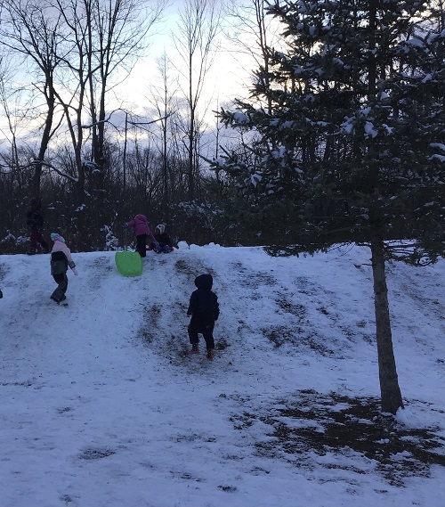 Children going up the snow hill. 