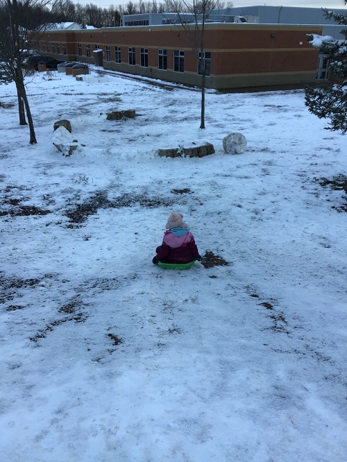 Child sledding down the hill