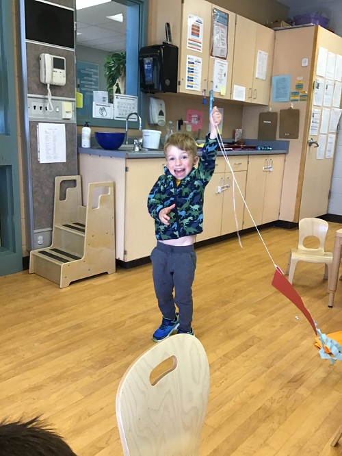 Child testing out their kite indoors.