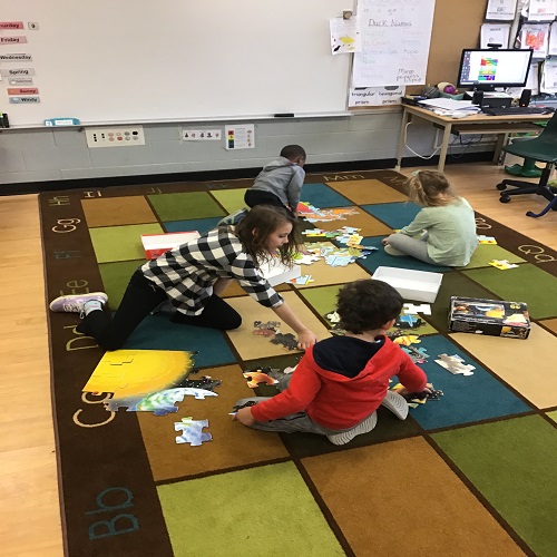 Groups of children working on puzzles. 