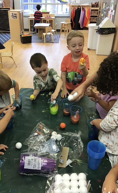 Children creating planets with Styrofoam balls and paint. 