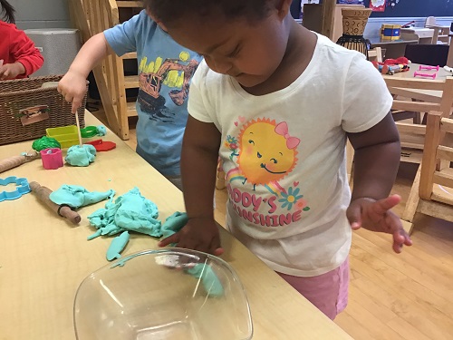 Child exploring playdough