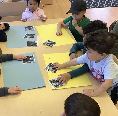 Children gluing their photos on paper. 