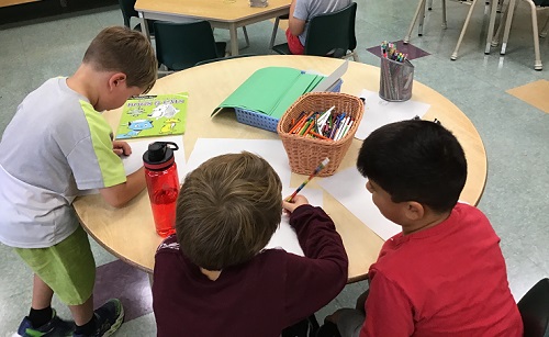 Children drawing together at a table.