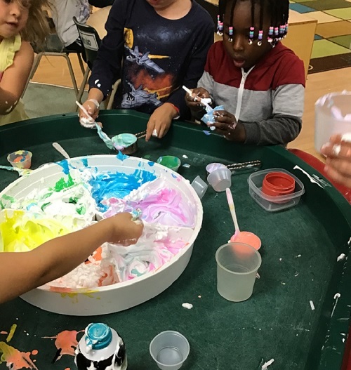 children exploring coloured shaving cream.