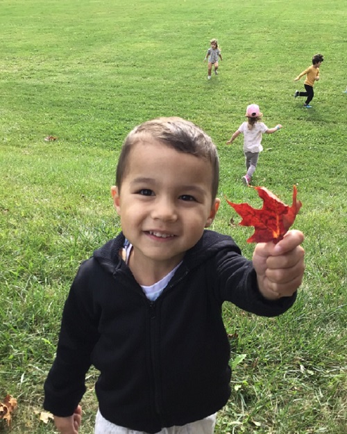 Child showing they found a fall leaf.