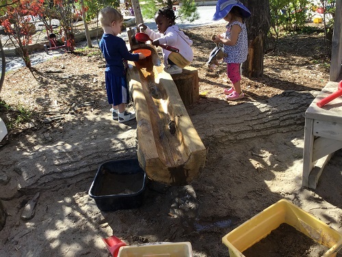 Children pumping water at the water feature.
