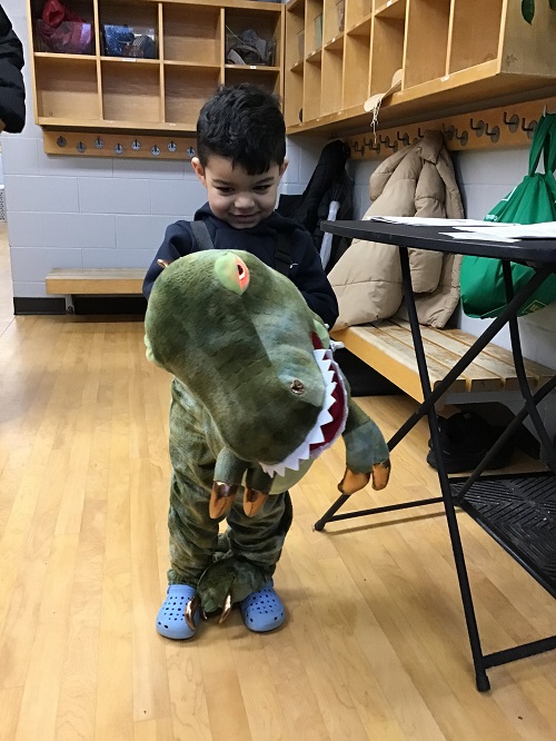 Child showing their dinosaur costume.