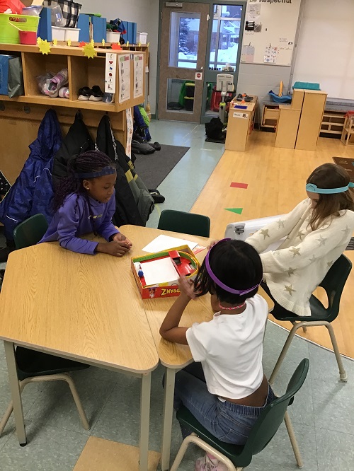 Children engaged in a game of "Hedbanz."