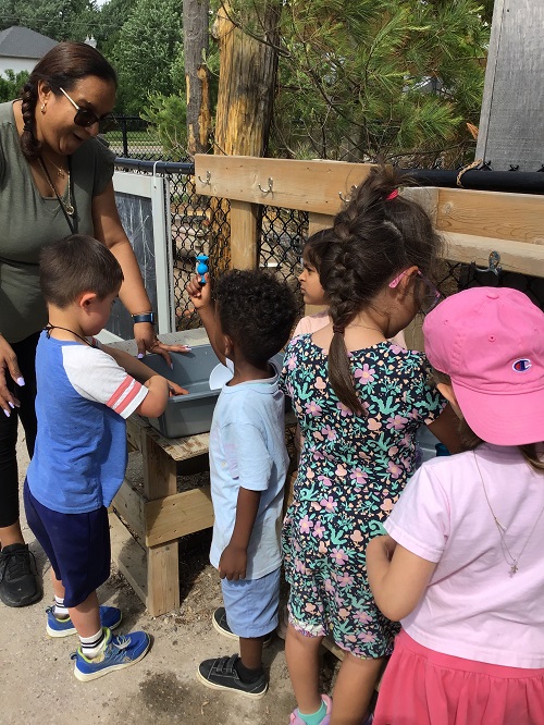 Children exploring water in the bins.