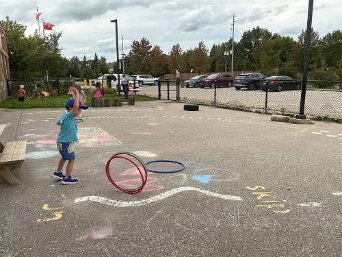 Children rolling the hula hoops.