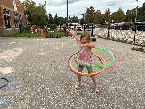 Child testing out four hula hoops at a time.