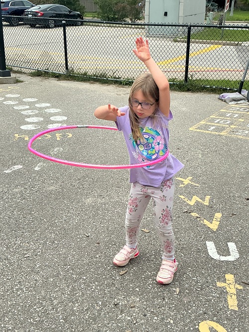 Child sohing their hula hoops skills.