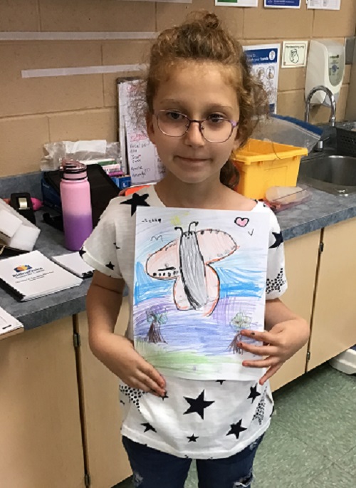 girl showing her drawing of a butterfly