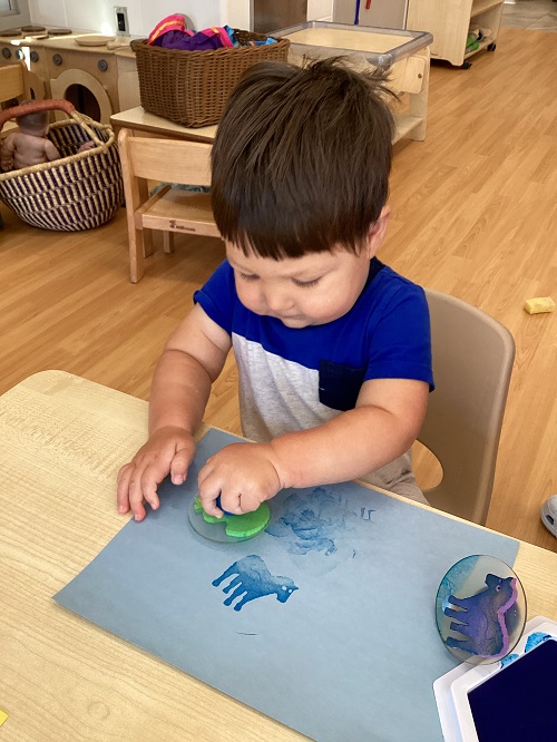 A toddler child using stamps