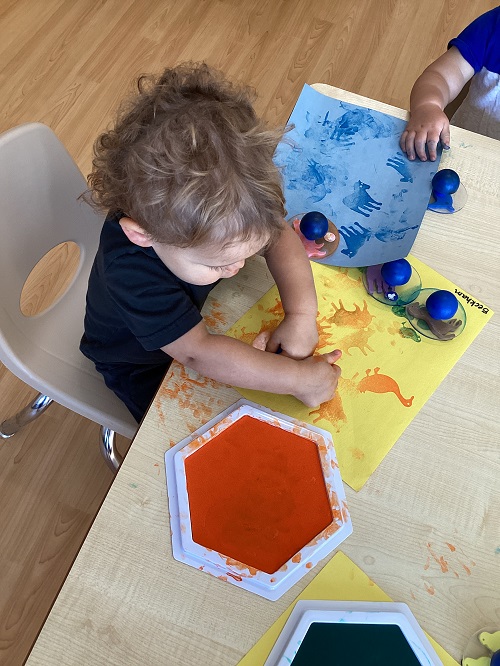 A toddler child using stamps