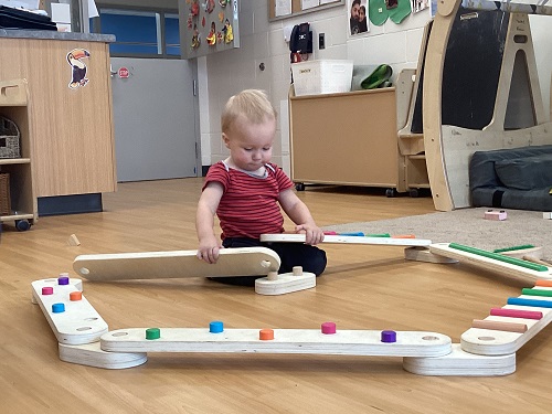 A child exploring on a balance beam.