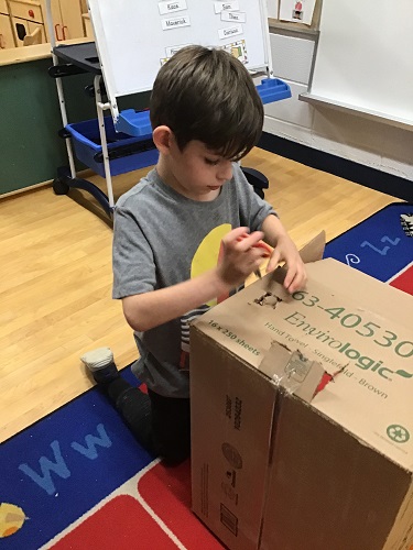 school age child working with a careboard box